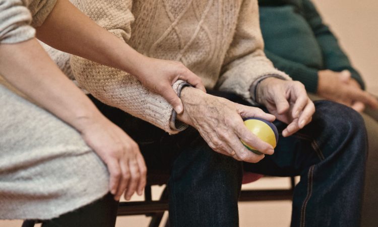 Elderly person holding a ball