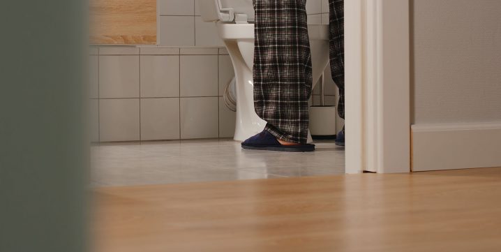 Homme debout devant la toilette