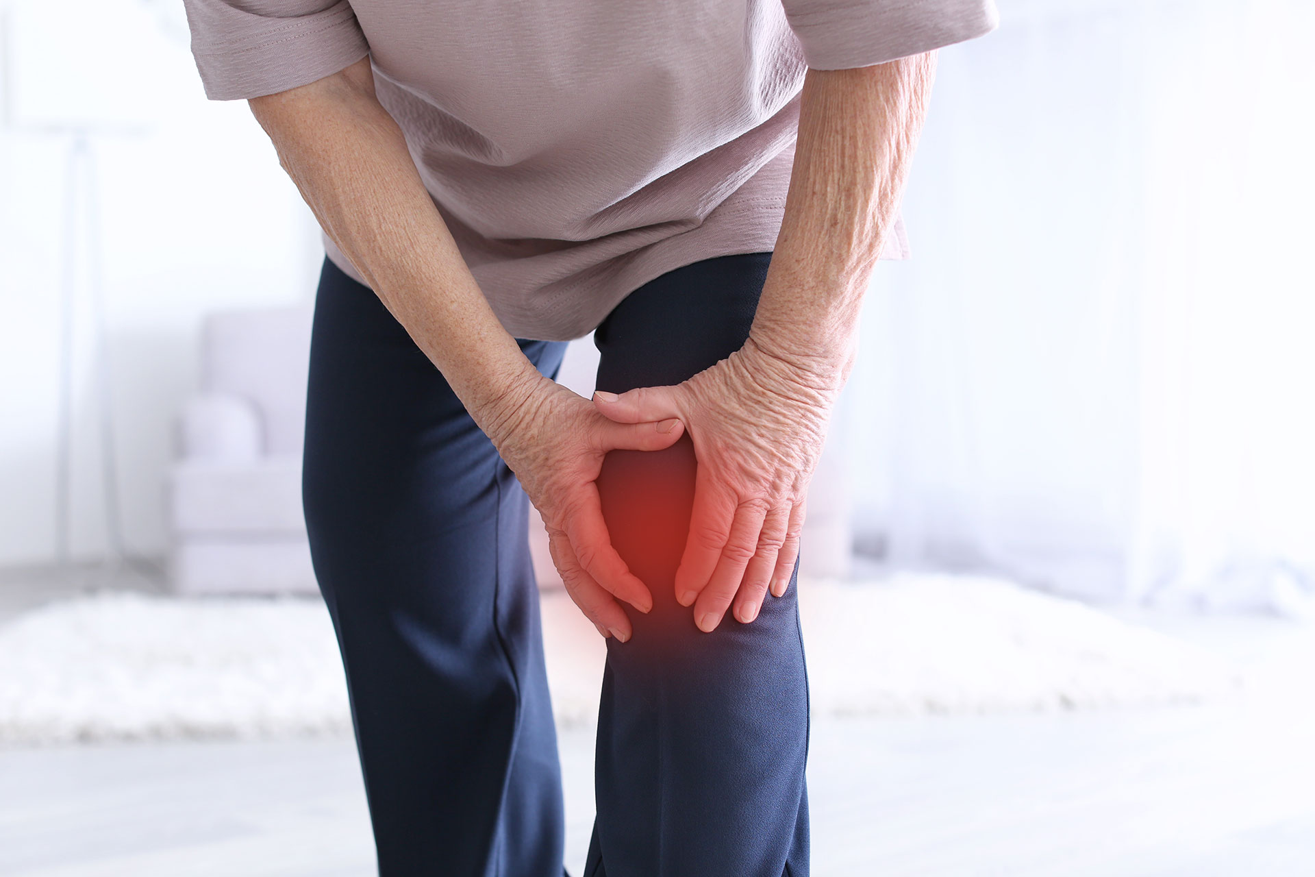 Elderly man holding his knee inflamed