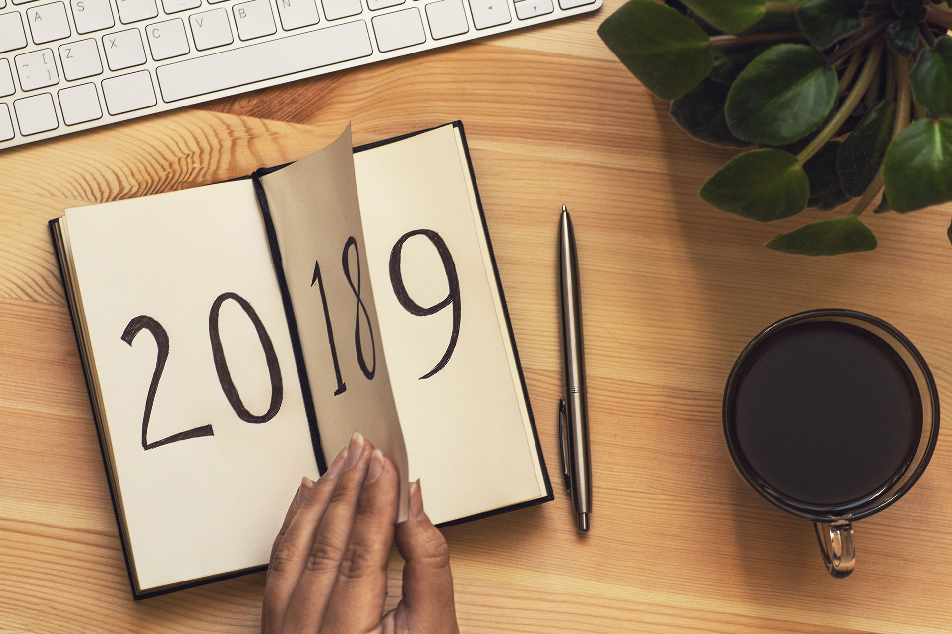 Notebook with a hand that turns the page, from 2018 to 2019