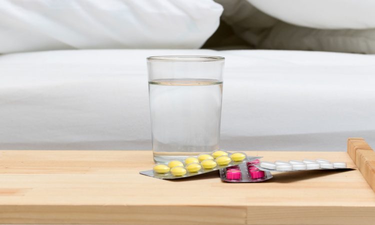 Vers d'eau avec des médicaments à côté du lit