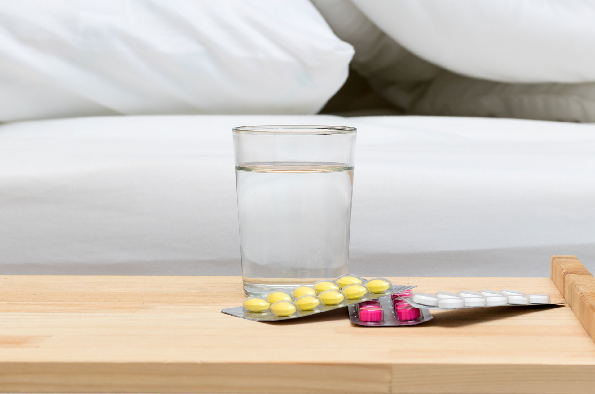 Water glass with drugs next to the bed