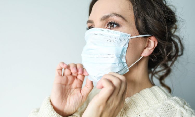 femme ajustant un masque de santé.