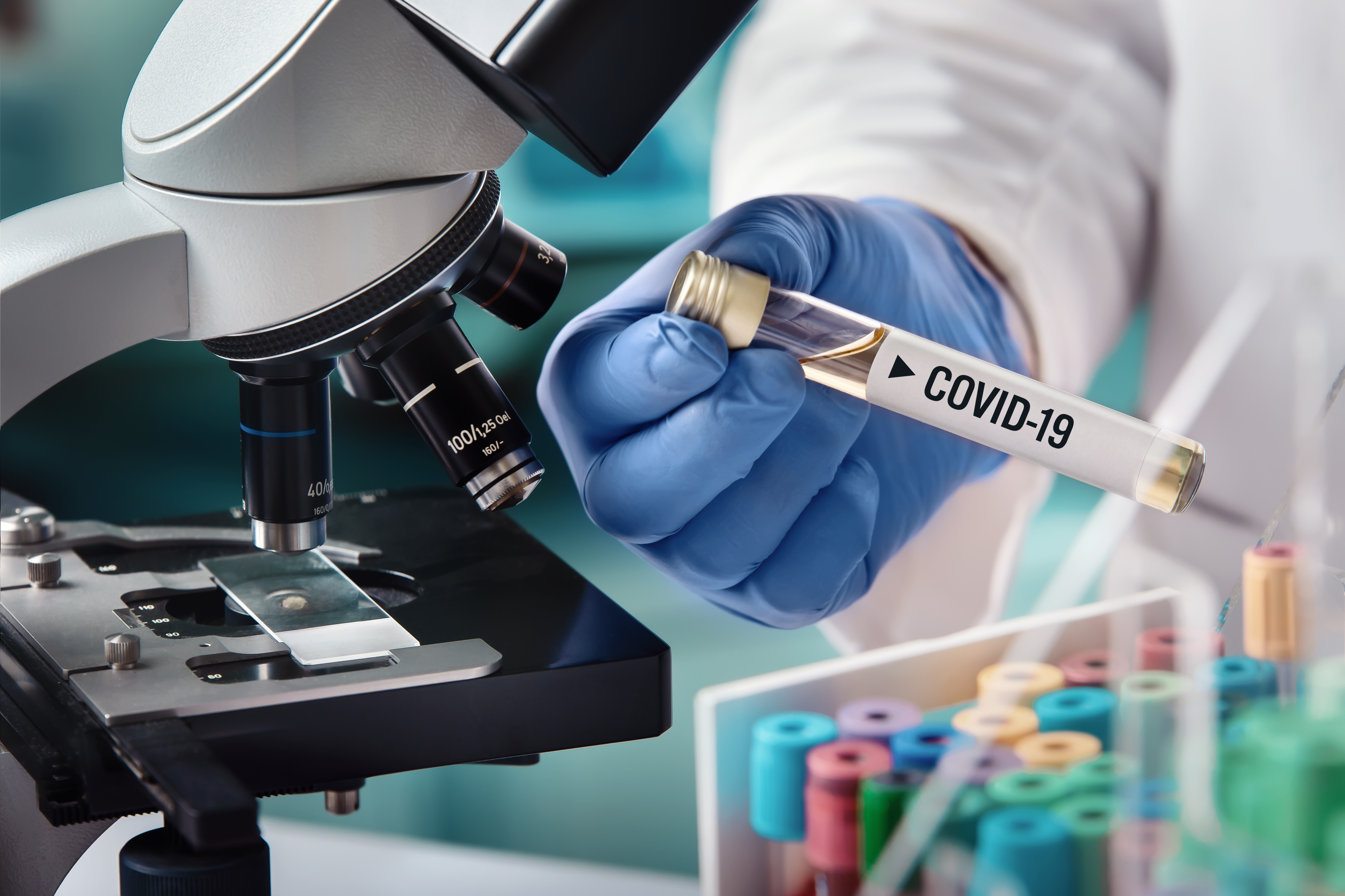 scientifique tenant éprouvette contenant le virus Covid-19