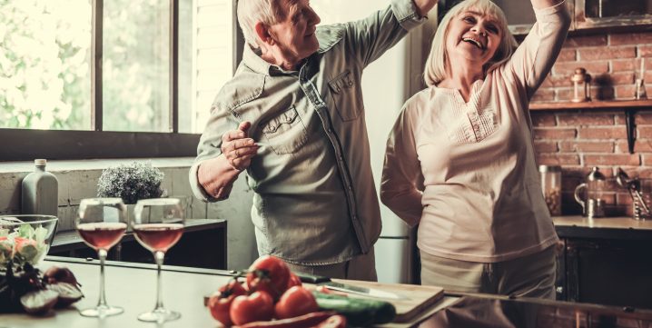 couple âgé dansant dans la cuisine.