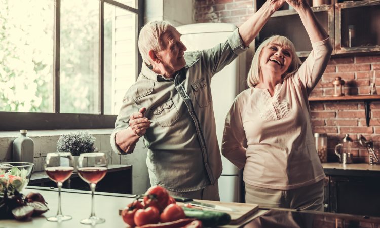 couple âgé dansant dans la cuisine.