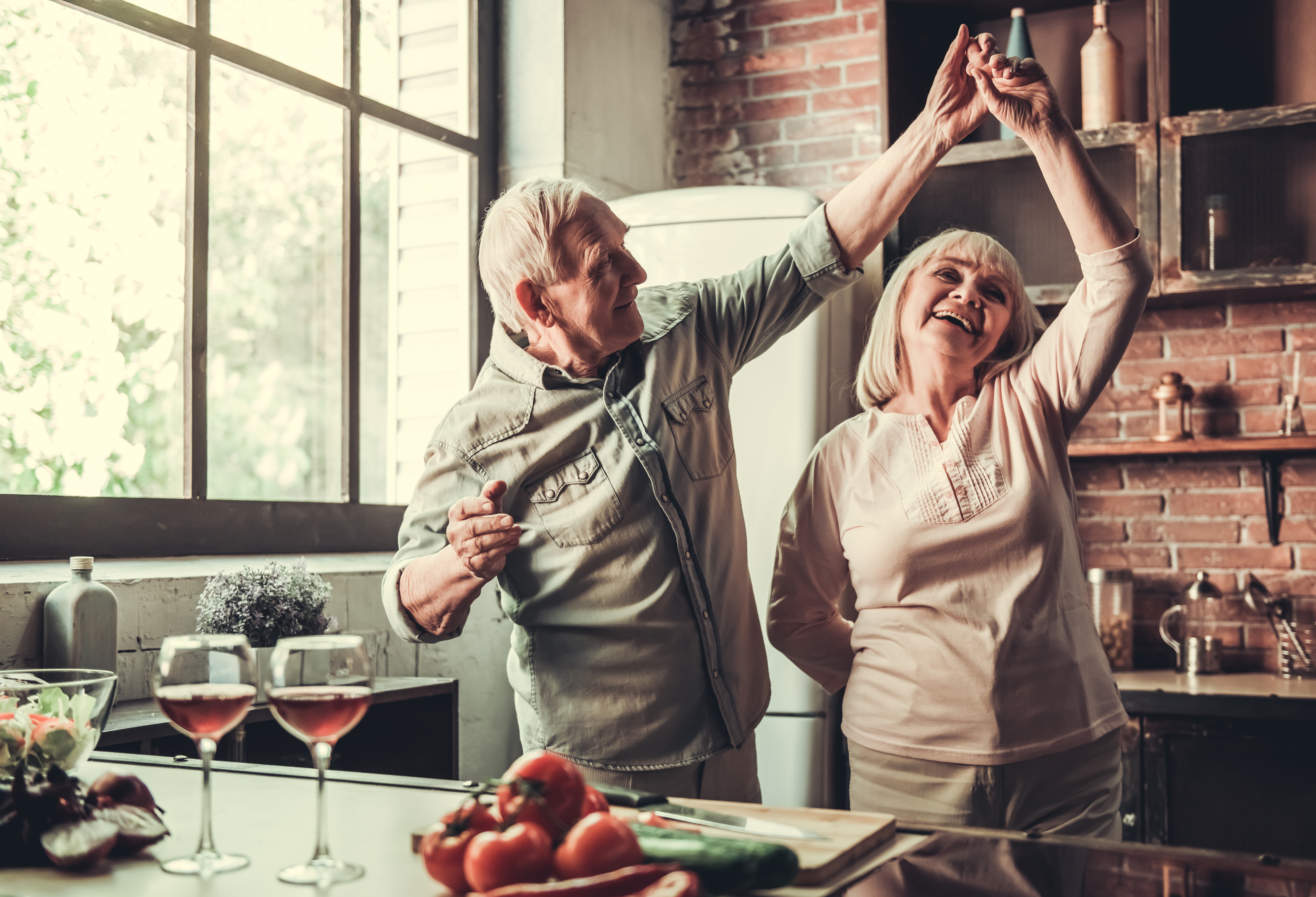 couple âgé dansant dans la cuisine.